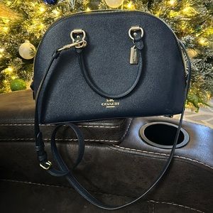 Midnight blue Coach handbag with shoulder strap. Gold metal accents.